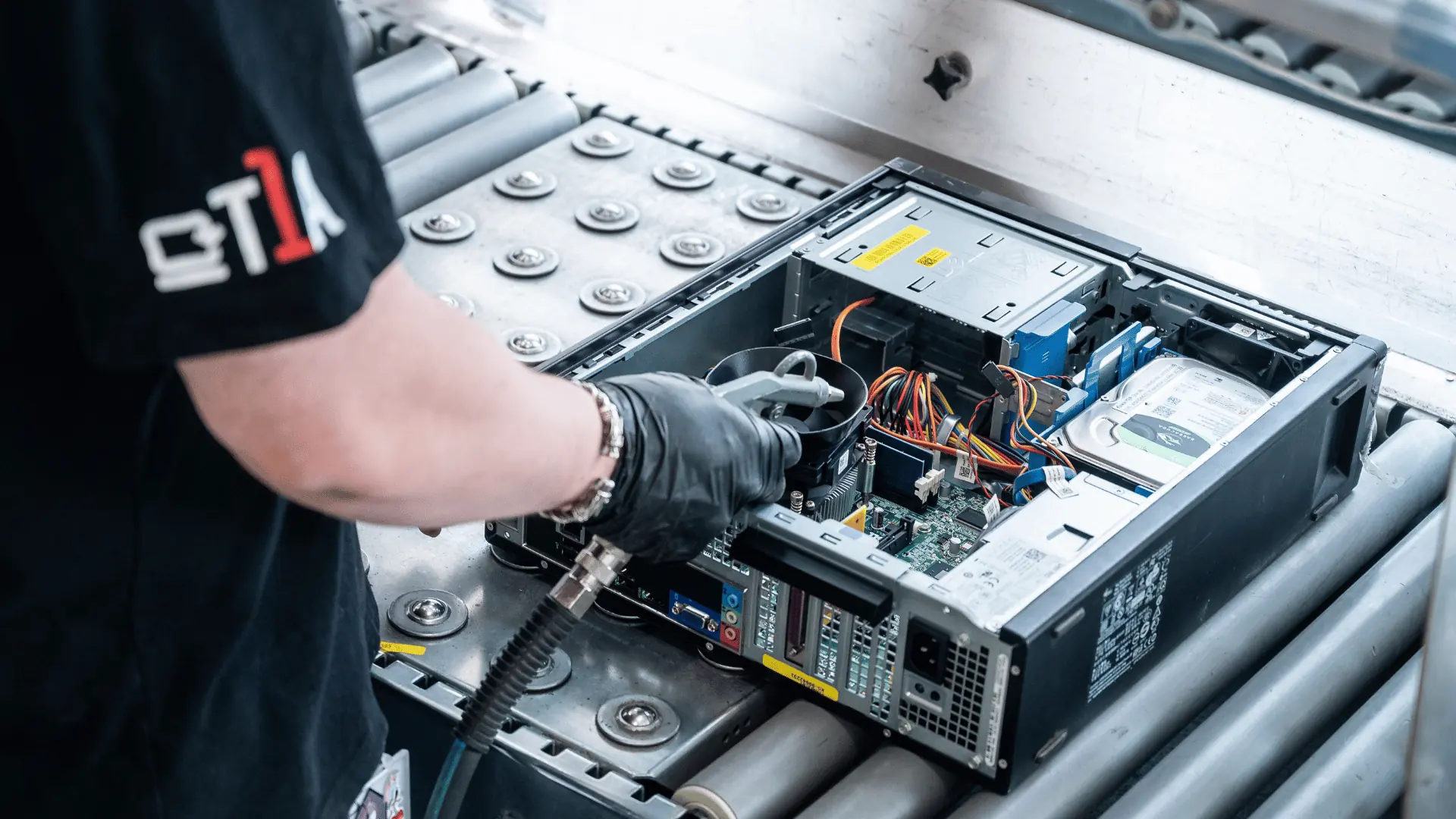 A technician working on an opened desktop machine on the roller line